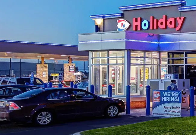 Holiday station store by night with a car in front of it